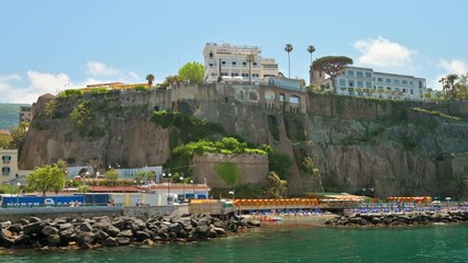 Wall Mural - View of the Tyrrhenian sea coast in Sorrento, Italy. Classic buildings, beach, cliff. View from a ship