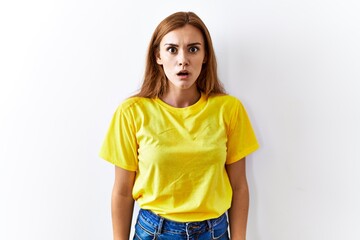 Canvas Print - Young brunette woman standing over isolated background afraid and shocked with surprise and amazed expression, fear and excited face.