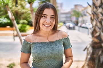 Wall Mural - Young hispanic girl smiling happy standing at the city.