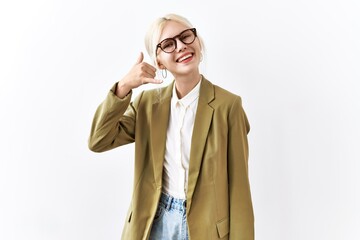 Wall Mural - Beautiful caucasian business woman standing over isolated background smiling doing phone gesture with hand and fingers like talking on the telephone. communicating concepts.