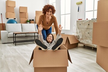 Wall Mural - Mature mother and down syndrome daughter moving to a new home, having fun inside box