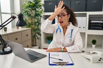 Sticker - Young hispanic woman wearing doctor uniform and stethoscope surprised with hand on head for mistake, remember error. forgot, bad memory concept.