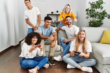 Poster - Group of young friends smiling happy playing video game at home.