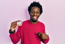 Young African American Man Holding Virtual Currency Ethereum Coin Pointing Finger To One Self Smiling Happy And Proud