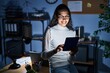 © Krakenimages.com - Young brazilian woman using touchpad at night working at the office with a happy and cool smile on face. lucky person.