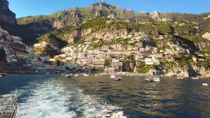 Wall Mural - View of the Tyrrhenian sea coast in Positano, Italy. Classic buildings, floating boats, greenery. View from a ship