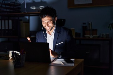 Sticker - Handsome latin man working at the office at night smiling happy and positive, thumb up doing excellent and approval sign