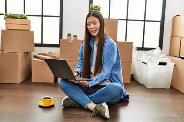 Sticker - Young chinese girl smiling happy using laptop sitting on the floor at new home