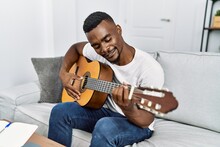 Young African American Man Smiling Confident Playing Guitar At Home