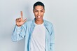 © Krakenimages.com - Young african american guy wearing casual clothes showing and pointing up with fingers number two while smiling confident and happy.