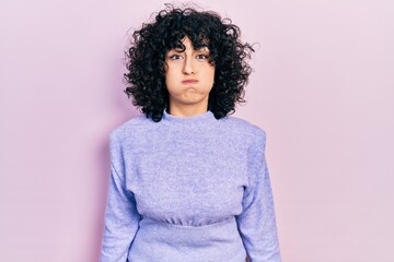 Poster - Young middle east woman wearing casual clothes puffing cheeks with funny face. mouth inflated with air, crazy expression.