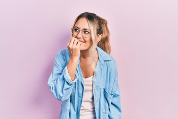 Canvas Print - Beautiful young blonde woman wearing casual clothes and glasses looking stressed and nervous with hands on mouth biting nails. anxiety problem.