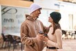 © Krakenimages.com - Mand and woman couple standing together drinking coffee at street