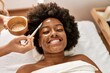 © Krakenimages.com - Young african american woman smiling confident having facial treatment at beauty center