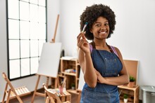 Young African American Woman Smiling Confident Holding Paintbrush At Art Studio