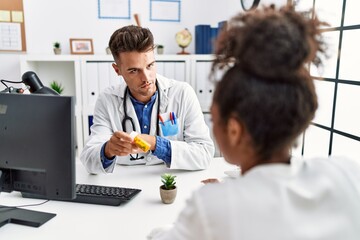 Wall Mural - Man and woman wearing doctor uniform having medical consultation prescribe pills at clinic