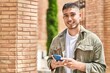 © Krakenimages.com - Young hispanic man smiling confident using smartphone at street