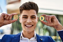 Young Man Smiling Confident Holding Bitcoin And Ethereum At Street