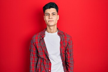 Wall Mural - Young hispanic man wearing casual clothes relaxed with serious expression on face. simple and natural looking at the camera.