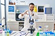 © Krakenimages.com - Young hispanic man with beard working at scientist laboratory smiling in love doing heart symbol shape with hands. romantic concept.