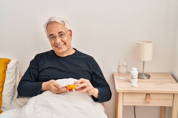 Poster - Senior man taking pills treatment sitting on bed at bedroom