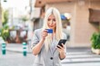 © Krakenimages.com - Young blonde woman using smartphone and credit card at street