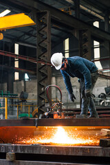 Wall Mural - Adult worker supervising a CNC oxygen acetylene cut machine in a factory