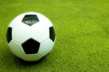  Black and white football ball on the green artificial grass field for sport background.