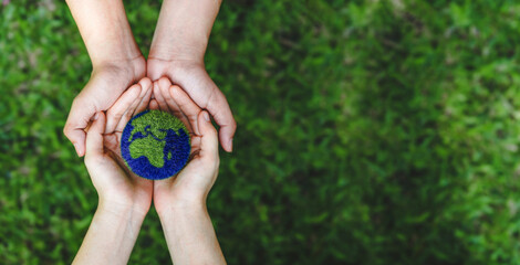 Many hands person holding the earth on a green background to protect nature Save and care World for sustainable. concept of the environment ecology and Earth Day