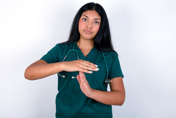 Doctor hispanic woman wearing surgeon uniform over white wall being upset showing a timeout gesture, needs stop, asks time for rest after hard work,