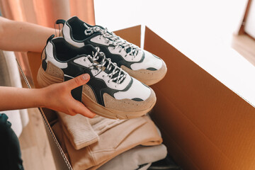 Wall Mural - Men's sneakers and clothes in a box, shopping unpacking