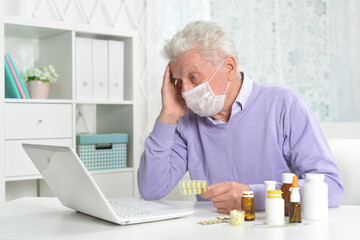 Sticker - ill senior man with facial mask using laptop