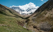 Georgia, Caucasus Mountains, Juta valley - river, green hill, blue sky, mountain from stones and snowy peak