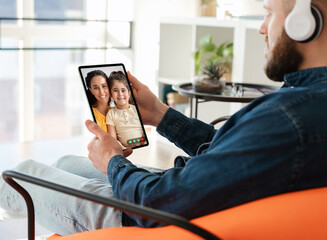 Wall Mural - Man with digital tablet video chatting with wife and daughter