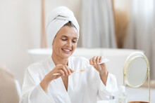 Positive Middle Aged Woman Brushing Her Teeth