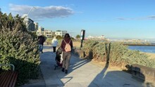 People Walking On A Footpath Next To The Ocean In Port Melbourne