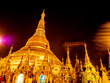 The golden pagodas and mondops are illuminated in the light of the night