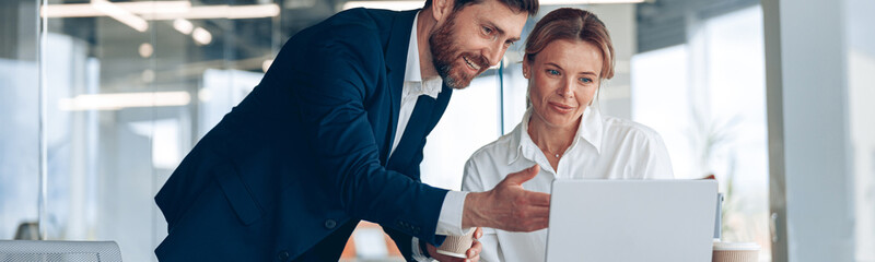 Wall Mural - female boss discussing online project with employee showing presentation to experienced team leader