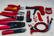 © Sergio62 - Red professional electrician tools on light wood background.