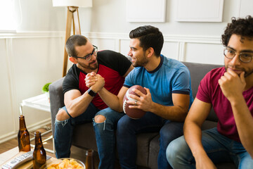 Friends celebrating winning the game with their favorite football team