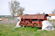 Photograph Of A Rusty Old Seed And Cereal Grain Planter Sitting On A Farm And Livestock Plot. Decline Of Agriculture. Selective Focus