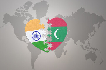 Wall Mural - puzzle heart with the national flag of india and maldives on a world map background.Concept.