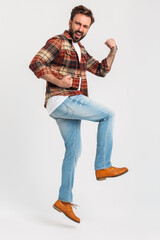 Wall Mural - handsome bearded man in hipster outfit dressed in jeans and checkered shirt