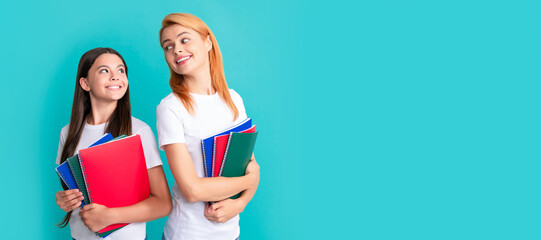 Canvas Print - Mother and daughter child banner, copy space, isolated background. cheerful school pupil and student holding notebooks, back to school.