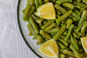 Wall Mural - A glass bowl with boiled green beans with extra virgin olive oil and lemon.