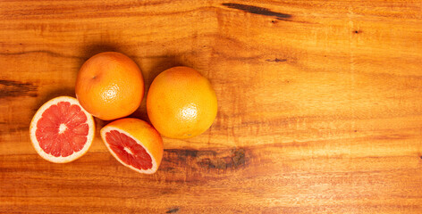 Wall Mural - Grapefruit, several grapefruits and one cut in half on a rustic wooden surface, selective focus.