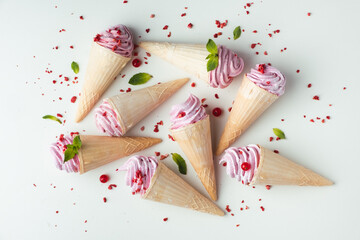 Canvas Print - Bunch of waffle cone ice cream with pink currant flavored filling. Refreshing summer dessert on the white background. Flat lay