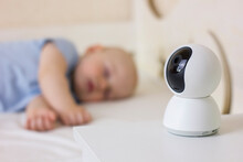 Cute Little Baby Boy Sleeping On Bed At Home With Baby Monitor Camera.