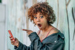 © carballo - surprised latin girl looking at mobile phone