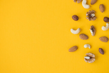Wall Mural - nuts mix for a healthy diet cashew, peanut, hazelnuts, walnuts, almonds on yellow background